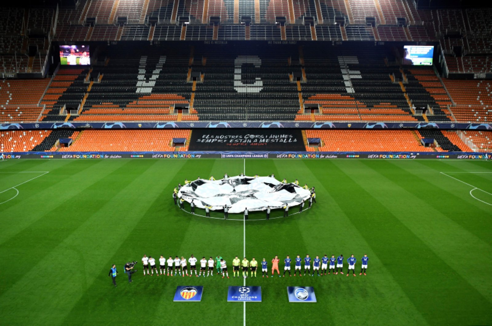 Atalanta and Valencia players line up ahead of the Champions League round of 16 second leg soccer match between Valencia and Atalanta in Valencia, Spain, Tuesday March 10, 2020. The match was played in an empty stadium because of the coronavirus outbreak. (UEFA via AP)