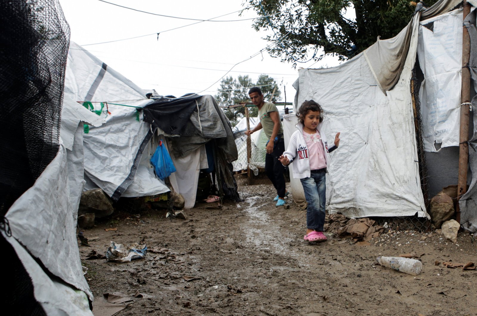 A girl makes her way next to tents at a makeshift camp for refugees and migrants next to the Moria camp, following a rainfall on the island of Lesbos, Greece, October 8, 2019. (REUTERS Photo)