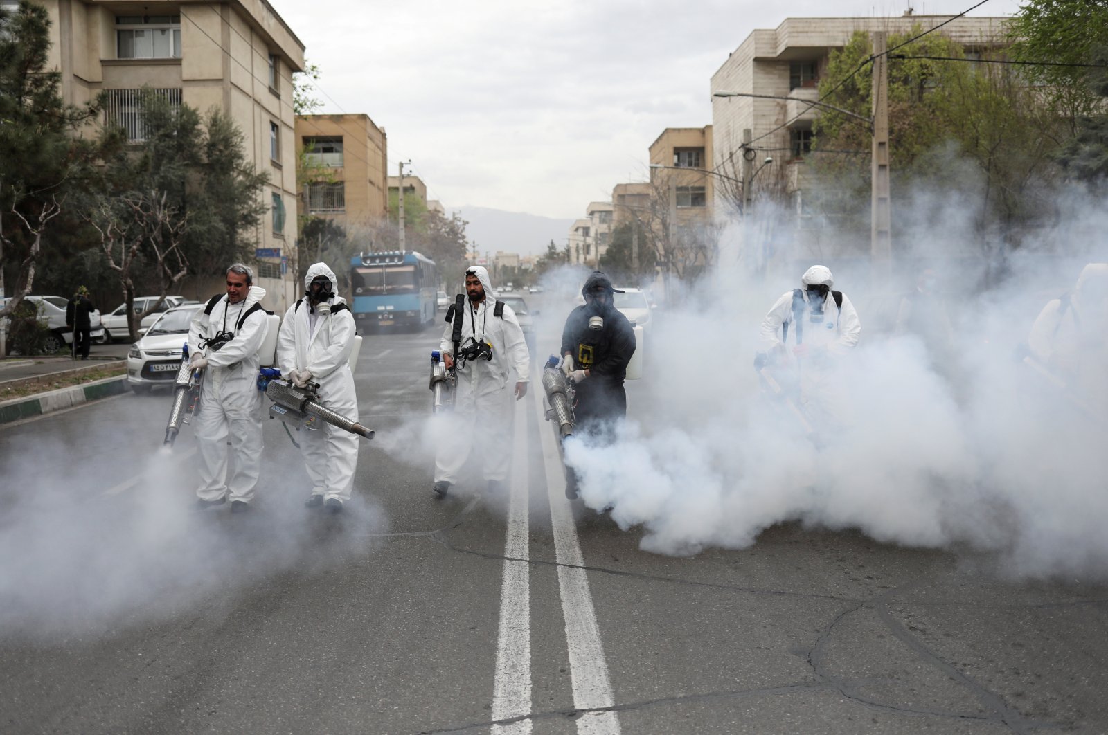 Members of firefighters wear protective face masks as they disinfect the streets, Tehran, March 18, 2020. (REUTERS Photo)
