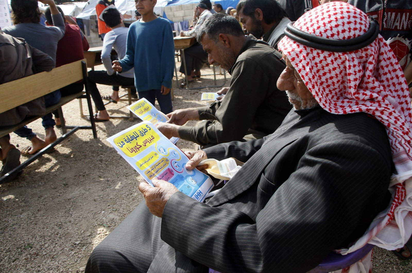 The Humanitarian Relief Foundation (İHH), is working to inform the displaced Syrians in Idlib about the coronavirus by hanging banners and handing out brochures, and conducting seminars, Thursday, March 26, 2020. (DHA)