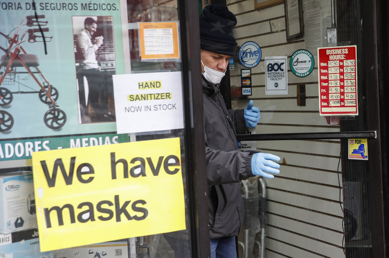 A customer leaves a shop advertising personal protective equipment near Elmhurst Hospital Center, New York, Wednesday, March 25, 2020. (AP Photo)