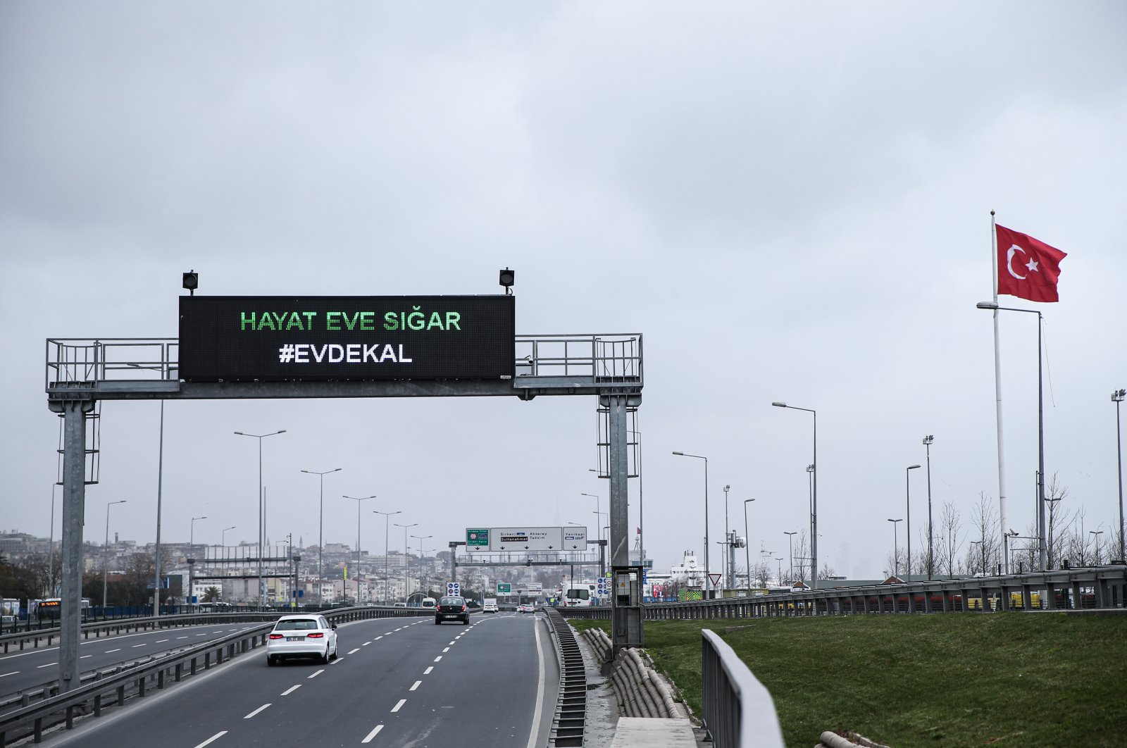 The sign on a nearly empty highway in Istanbul reads, "Life Fits Inside the House – Stay Home" (AA Photo)