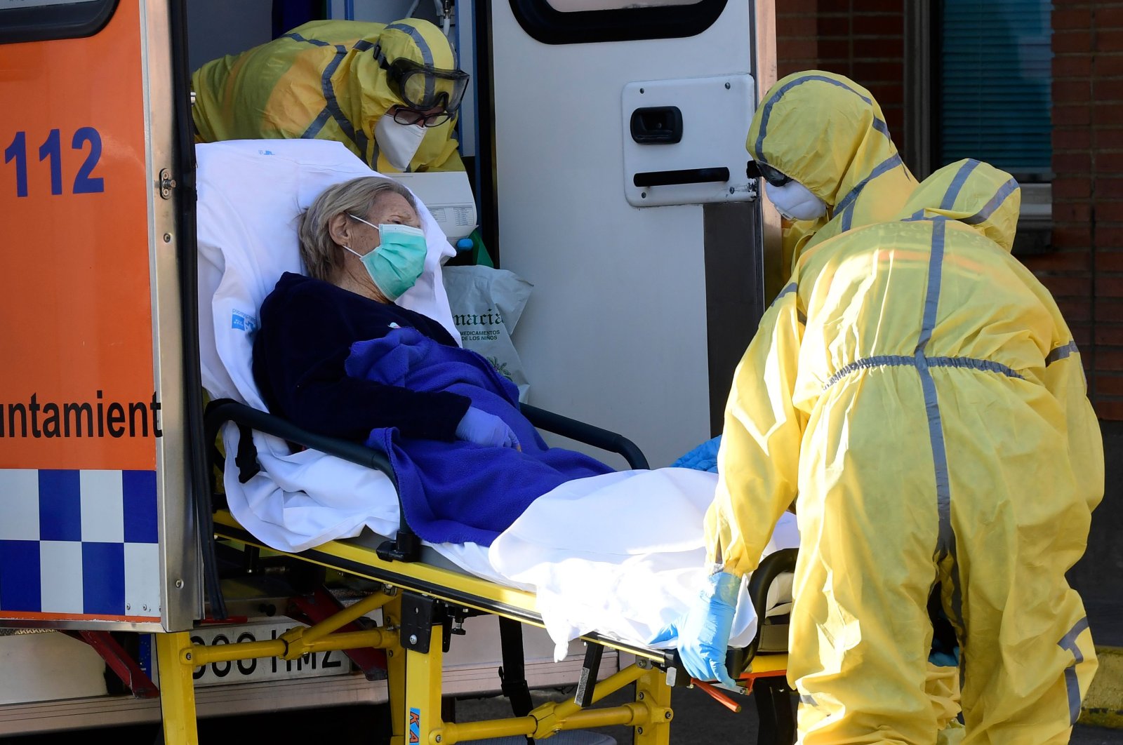 Civil Defense members carry a patient on a stretcher as they arrive at the Severo Ochoa hospital in Leganes, on March 26, 2020. - Spain's coronavirus death toll surged above 4,000 today but the increase in both fatalities and new infections slowed, leaving officials hopeful a nationwide lockdown is starting to curb the spread of the disease. (AFP Photo)