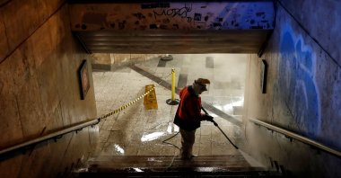 A worker cleans a flight of stairs of an underpass, amid the COVID-19 outbreak, in downtown Budapest, Hungary, Wednesday, March 25, 2020. (Reuters Photo)