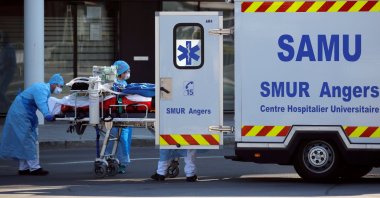 Medical staff move a patient from a special high-speed train to an ambulance during a transfer operation of people infected with COVID-19, from Strasbourg to hospitals in western France, Angers, Thursday, March 26, 2020. (Reuters Photo)