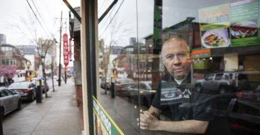 Paul Boutros, the owner of East Side Pockets, a small restaurant near Brown University, looks out onto an empty street since students were sent home two weeks ago, Wednesday, March 25, 2020, in Providence, R.I. (AP Photo)