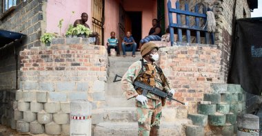 A South African National Defence Force (SANDF) soldier stands in front of a house as he patrols the streets in Alexandra, Johannesburg, on Friday, March 27, 2020 during a joint operation with the South African Police Service (SAPS) in order prevent the spread of the COVID-19 coronavirus outbreak. (AFP Photo)