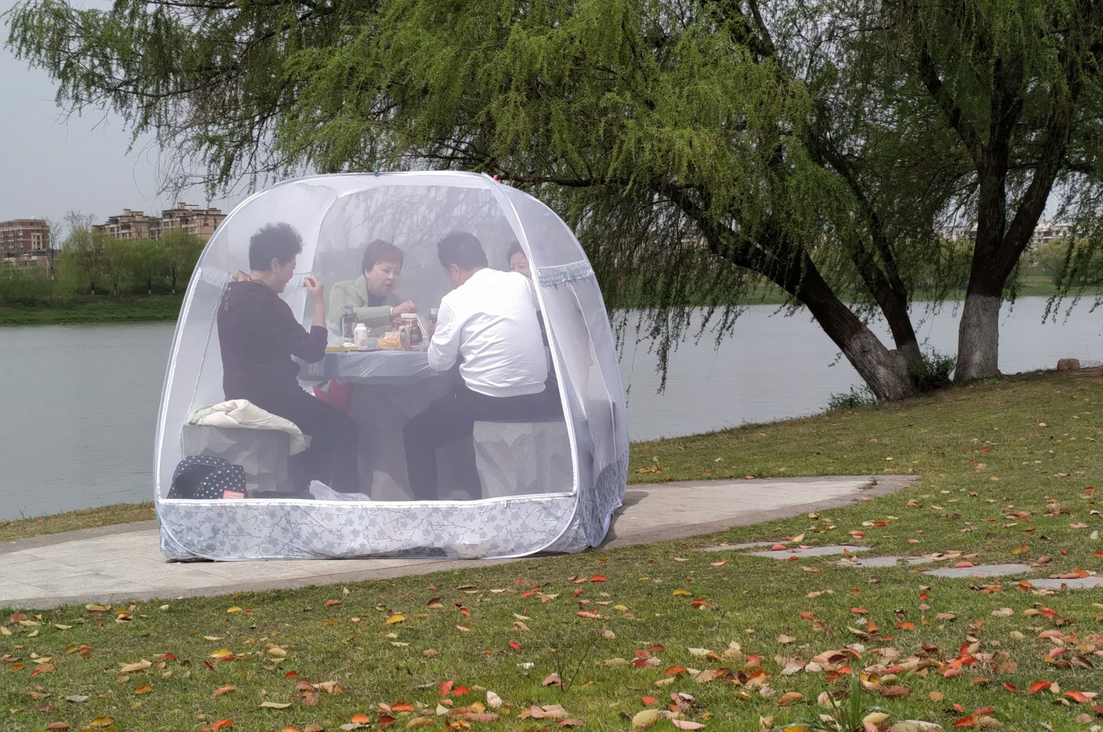People enjoy a meal inside a tent to prevent the coronavirus disease, at a park in Nanjing, Jiangsu province, China, Tuesday, March 24, 2020. (Reuters Photo)