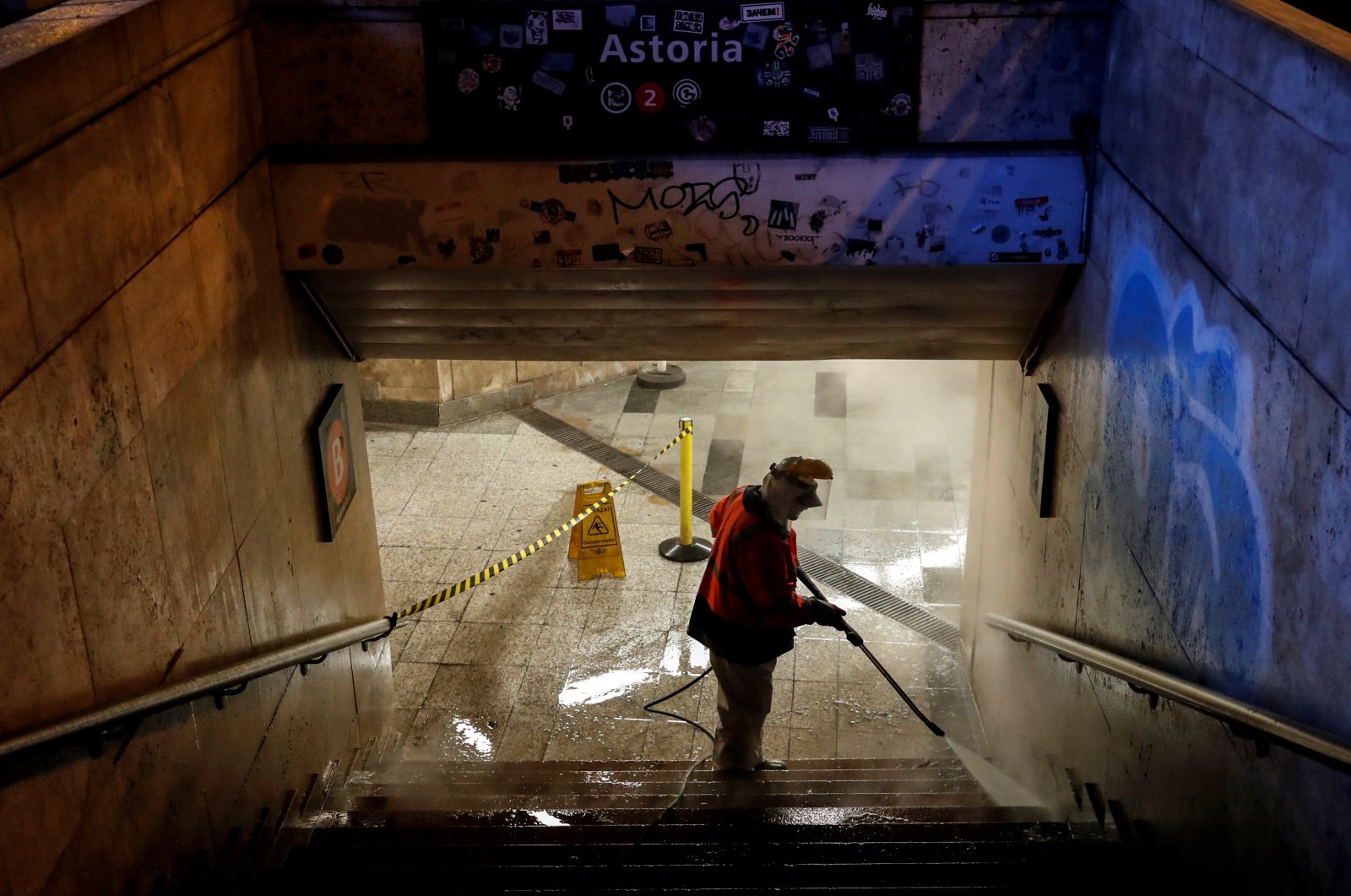 A worker cleans a flight of stairs of an underpass, amid the COVID-19 outbreak, in downtown Budapest, Hungary, Wednesday, March 25, 2020. (Reuters Photo)