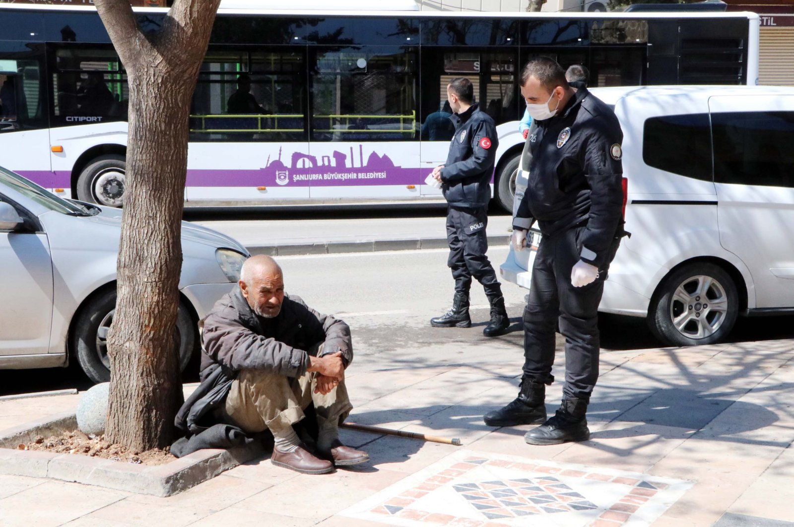 A police officer tries to convince a 68-year-old homeless man to let him take him to a shelter in Şanlıurfa, Sunday, March 22, 2020. (DHA Photo)