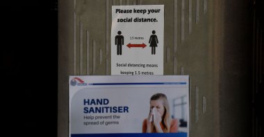 A sign reminding people of social distancing hangs inside a food court where restaurants are closed, Sydney, March 25, 2020. (AFP Photo)