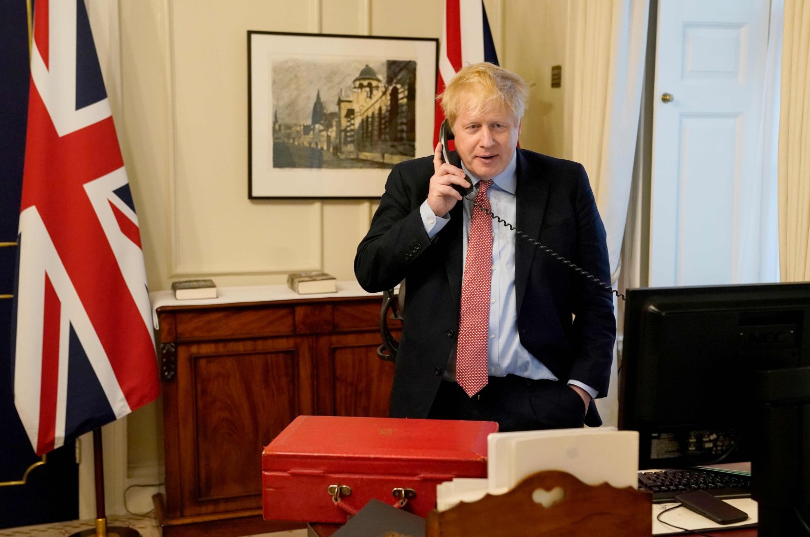 Britain's Prime Minister Boris Johnson on the telephone in his office in 10 Downing Street, to Queen Elizabeth II for their weekly audience during the coronavirus crisis, Wednesday, March 25, 2020. (AFP Photo)