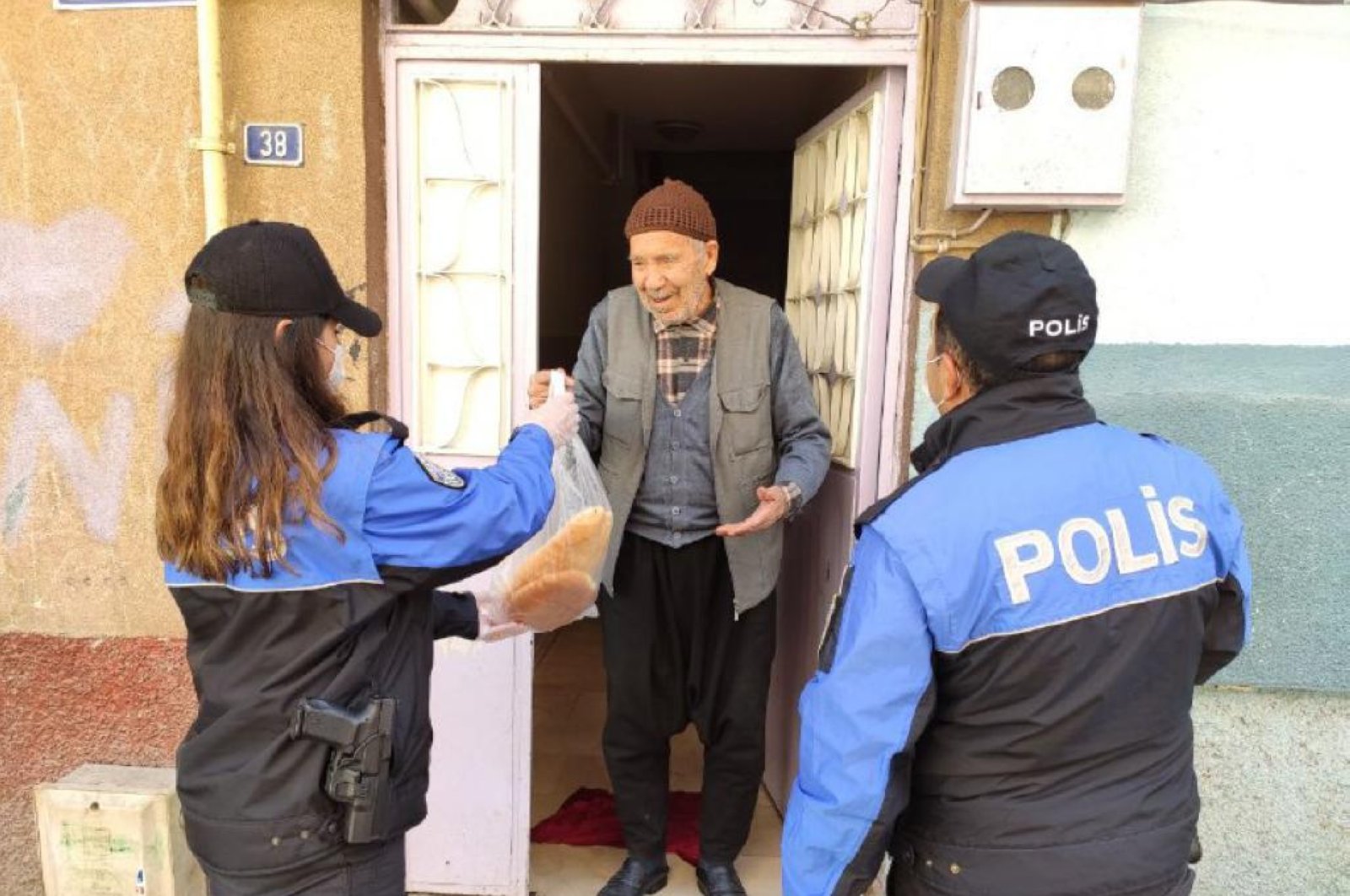 Police officers deliver bread to an elderly man in Gaziantep, Turkey, Wednesday, March 25, 2020. (AA Photo)