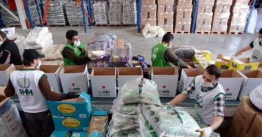 Aid workers at the IHH load packages to be distributed to the needy as part of coronavirus relief efforts, Friday, March 27, 2020. (AA Photo)
