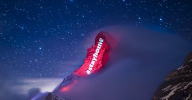The iconic Matterhorn mountain is illuminated by Swiss light artist Gerry Hofstetter aiming to send messages of hope, support and solidarity to the ones sufferings from the global coronavirus disease, in the alpine resort of Zermatt, Switzerland, Thursday, March 26, 2020. (AP Photo)