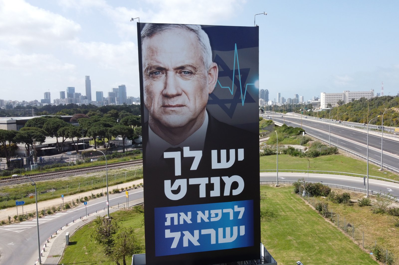 A billboard shows Israeli parliament speaker Benny Gantz on a mostly empty freeway because of the coronavirus in Tel Aviv, Israel, Sunday, March 29, 2020. The Hebrew writing says you have a mandate to heal Israel. (AP Photo)