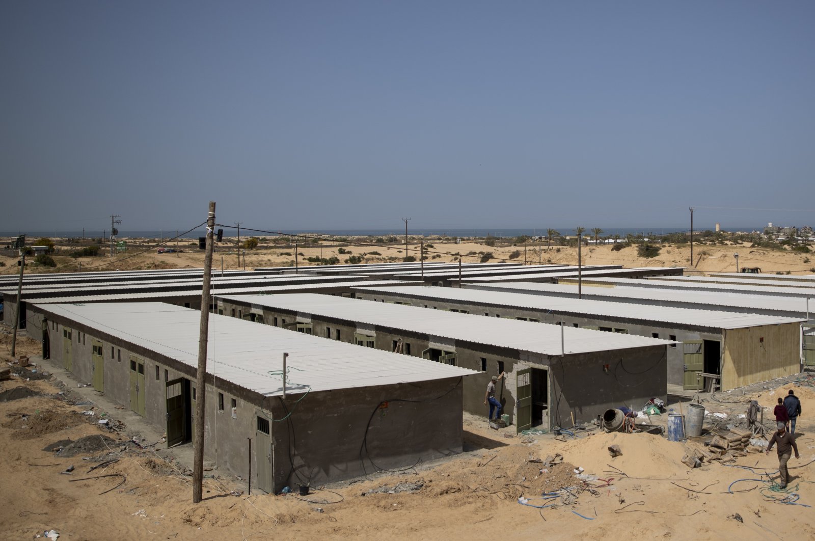 Palestinian workers construct a quarantine complex to be used for coronavirus cases, in the southern Gaza Strip, Monday, March 30, 2020. (AP Photo)