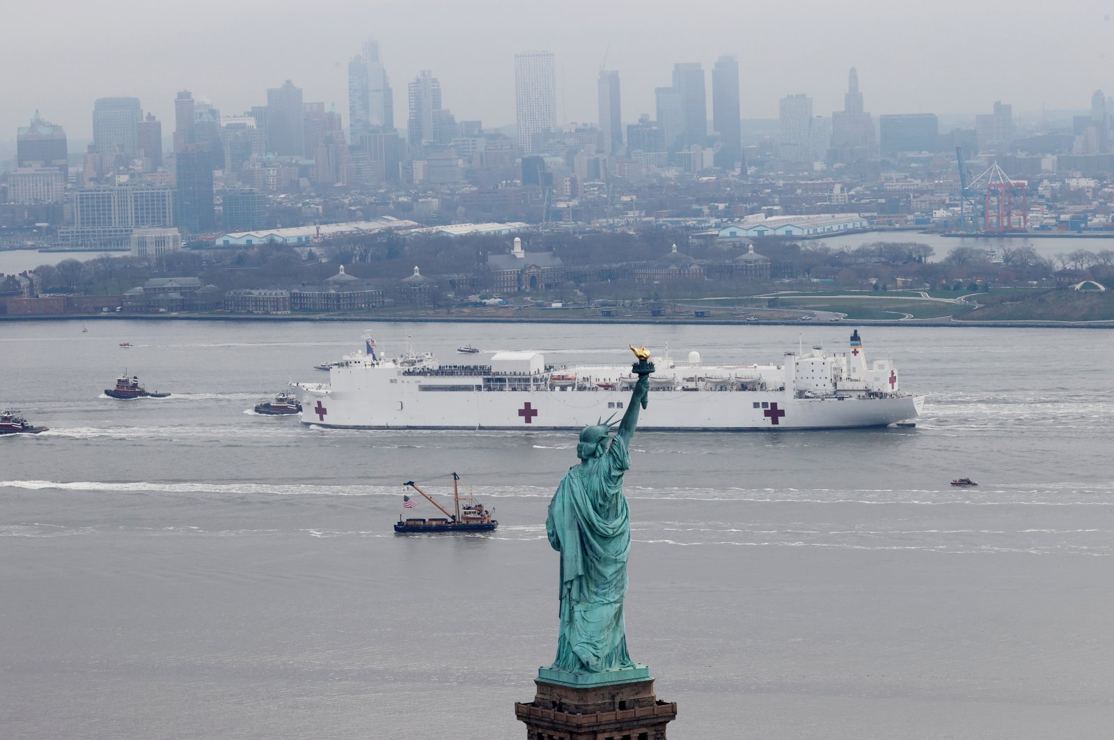 The USNS Comfort passes the Statue of Liberty as it enters New York Harbor during the outbreak of the coronavirus disease (COVID-19) in New York City, U.S., Monday, March 30, 2020. (Reuters Photo)