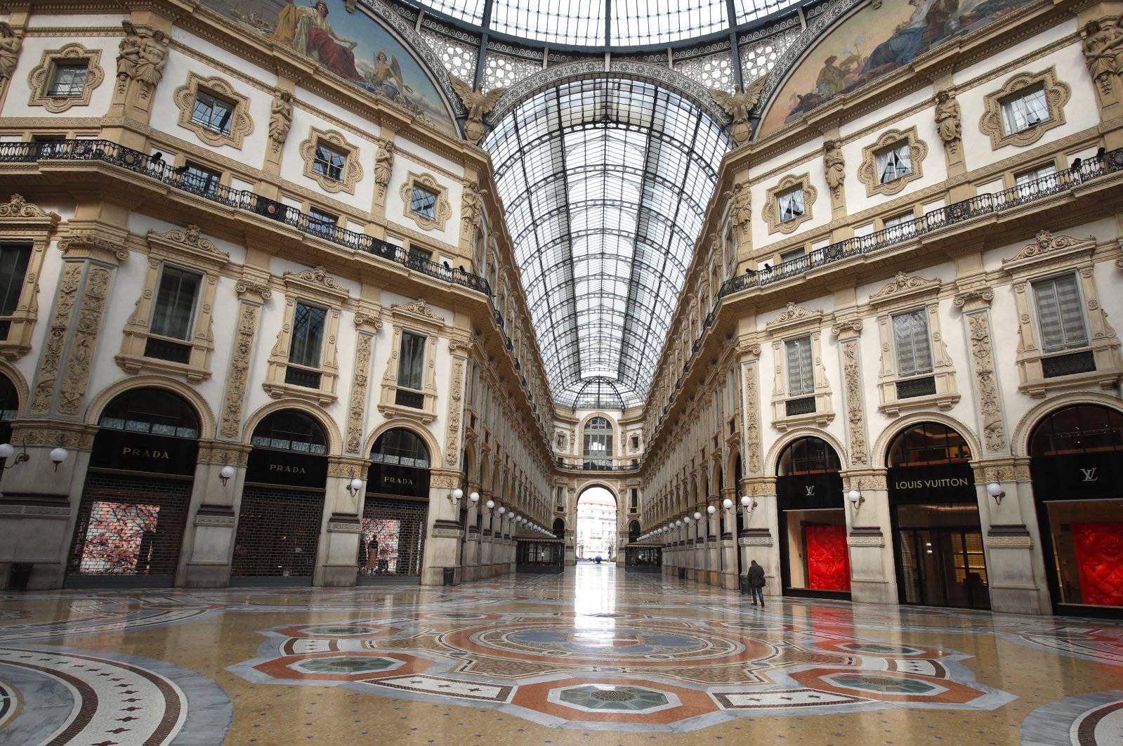 In this photo, a man walks in an empty Vittorio Emanuele II gallery shopping arcade, in downtown Milan, Italy, Sunday, March 22, 2020. (AP Photo)