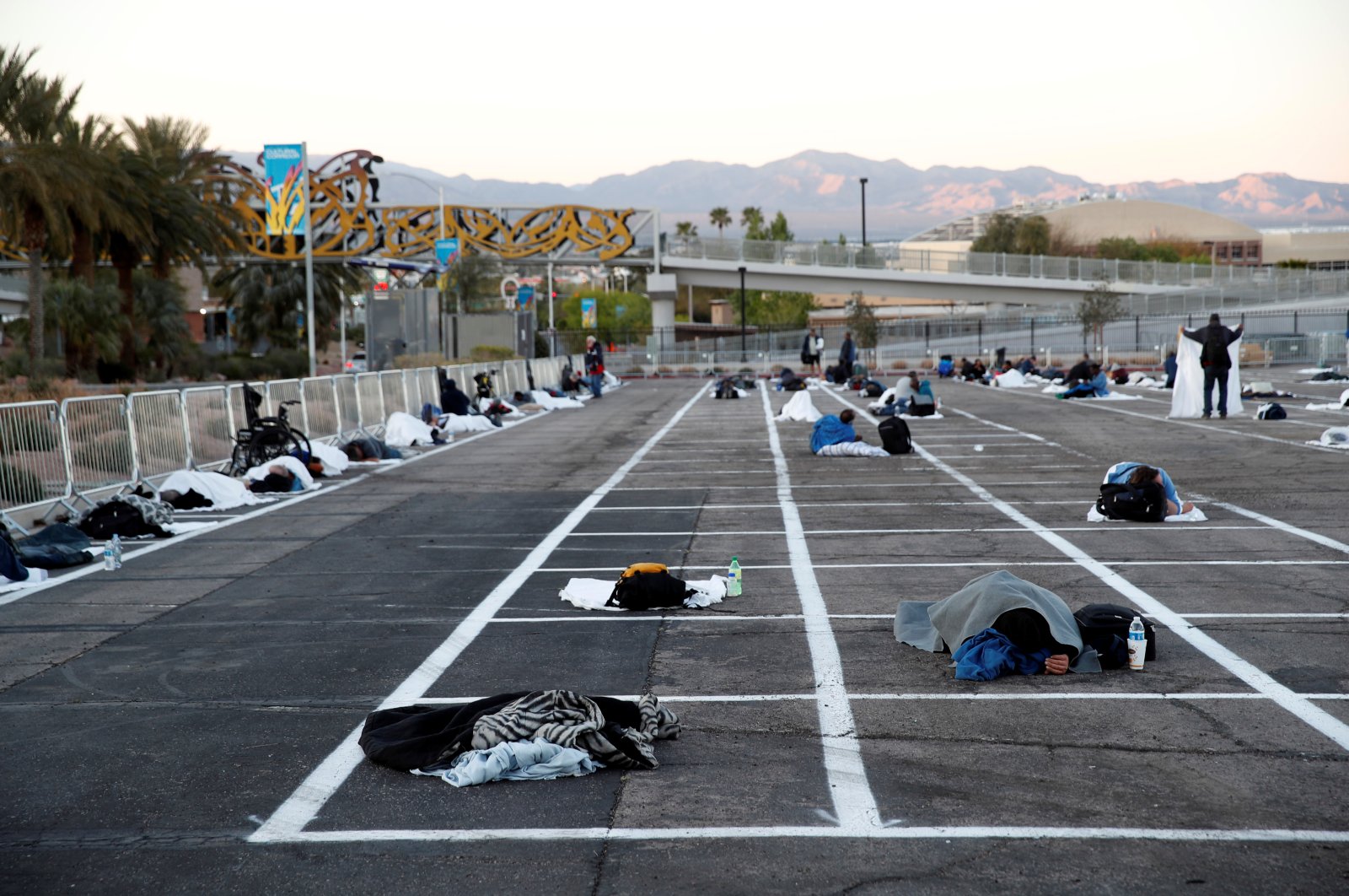 Homeless people sleep in a temporary parking lot shelter at Cashman Center, with spaces marked for social distancing to help slow the spread of coronavirus disease (COVID-19) in Las Vegas, Nevada, U.S., Monday, March 30, 2020. (Reuters Photo)