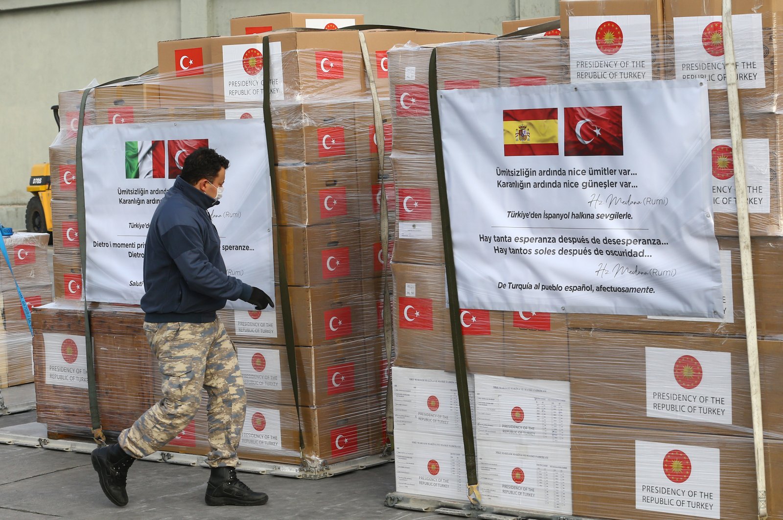 A soldier walks by packages of medical equipment bearing messages in Spanish and Turkish, in Ankara, Turkey, Wednesday, April 1, 2020. (AA Photo)