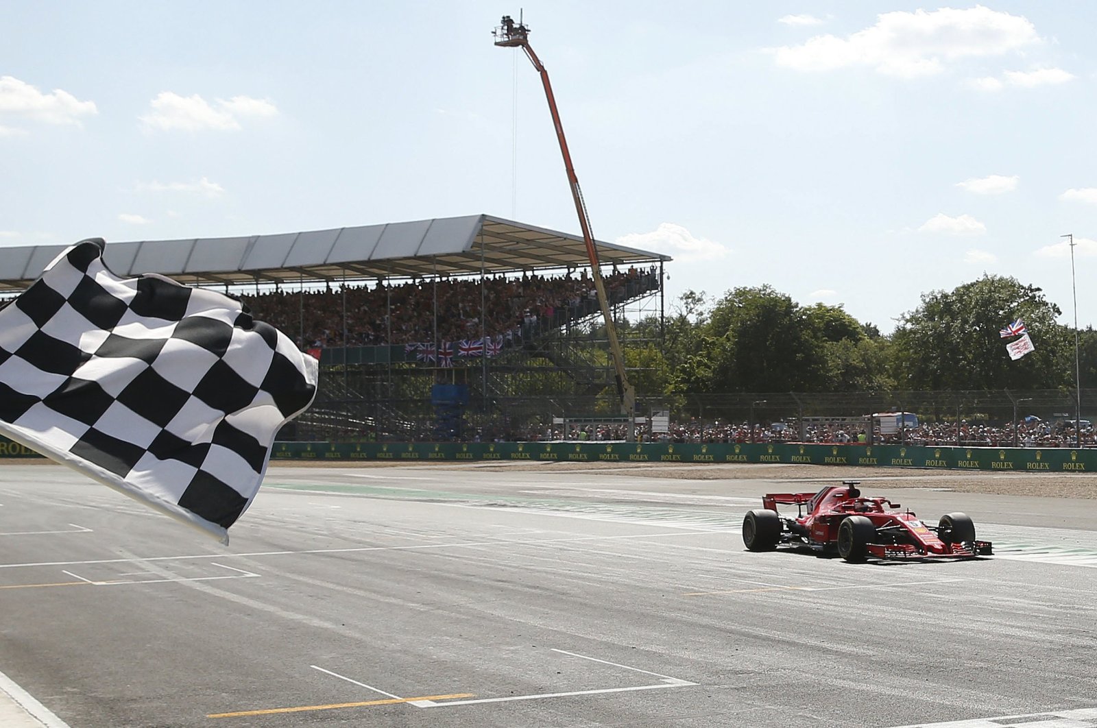 Ferrari driver Sebastian Vettel crosses the finish line to win the British GP, Silverstone, England, July 8, 2018. (AP Photo)