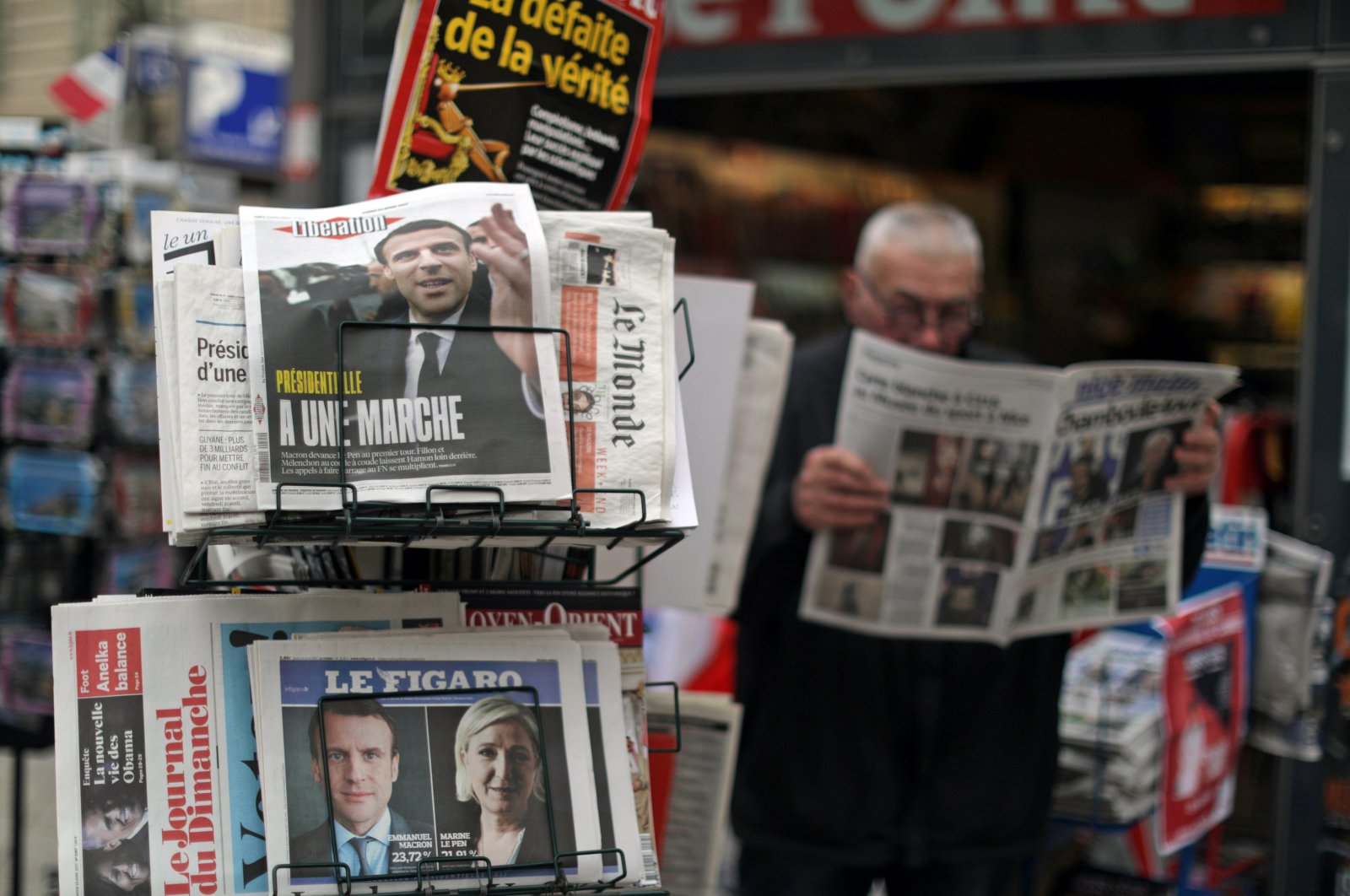 A man reads the local newspaper near a rack which displays copies of French daily newspapers with front pages about the results in France's Presidential election in Nice April 24, 2017. (REUTERS Photo)