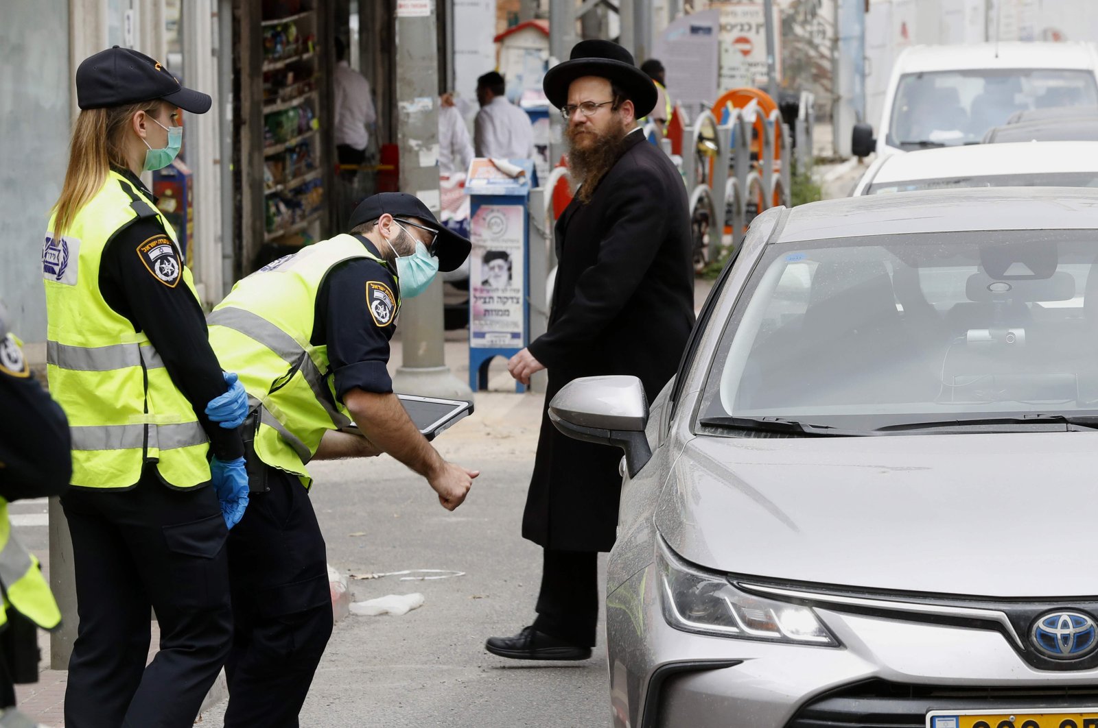 Israeli police talk to a driver at a checkpoint in the city of Bnei Brak, a city near Tel Aviv with a largely ultra-Orthodox population, part of measures imposed by Israeli authorities to curb the spread of COVID-19, Tuesday, March 31, 2020. (AFP Photo)