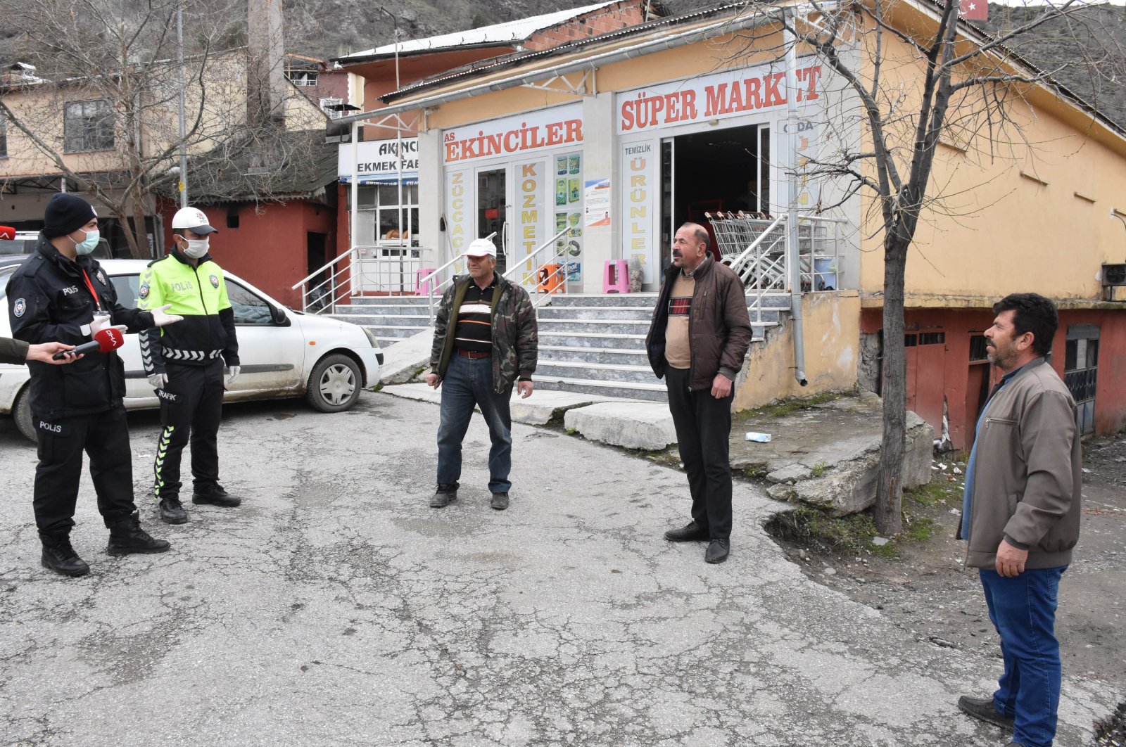 Police officers warn three men caught walking too close together, in Akıncılar, Sivas, Turkey, Wednesday, April 1, 2020. (DHA Photo)