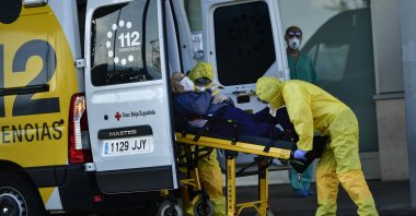 Staff health medical ambulances wearing special equipment to prevent the spread of coronavirus COVID-19 arriving with a patient at San Pedro hospital, in Logrono, northern Spain, Saturday, March 28, 2020. (AP Photo)