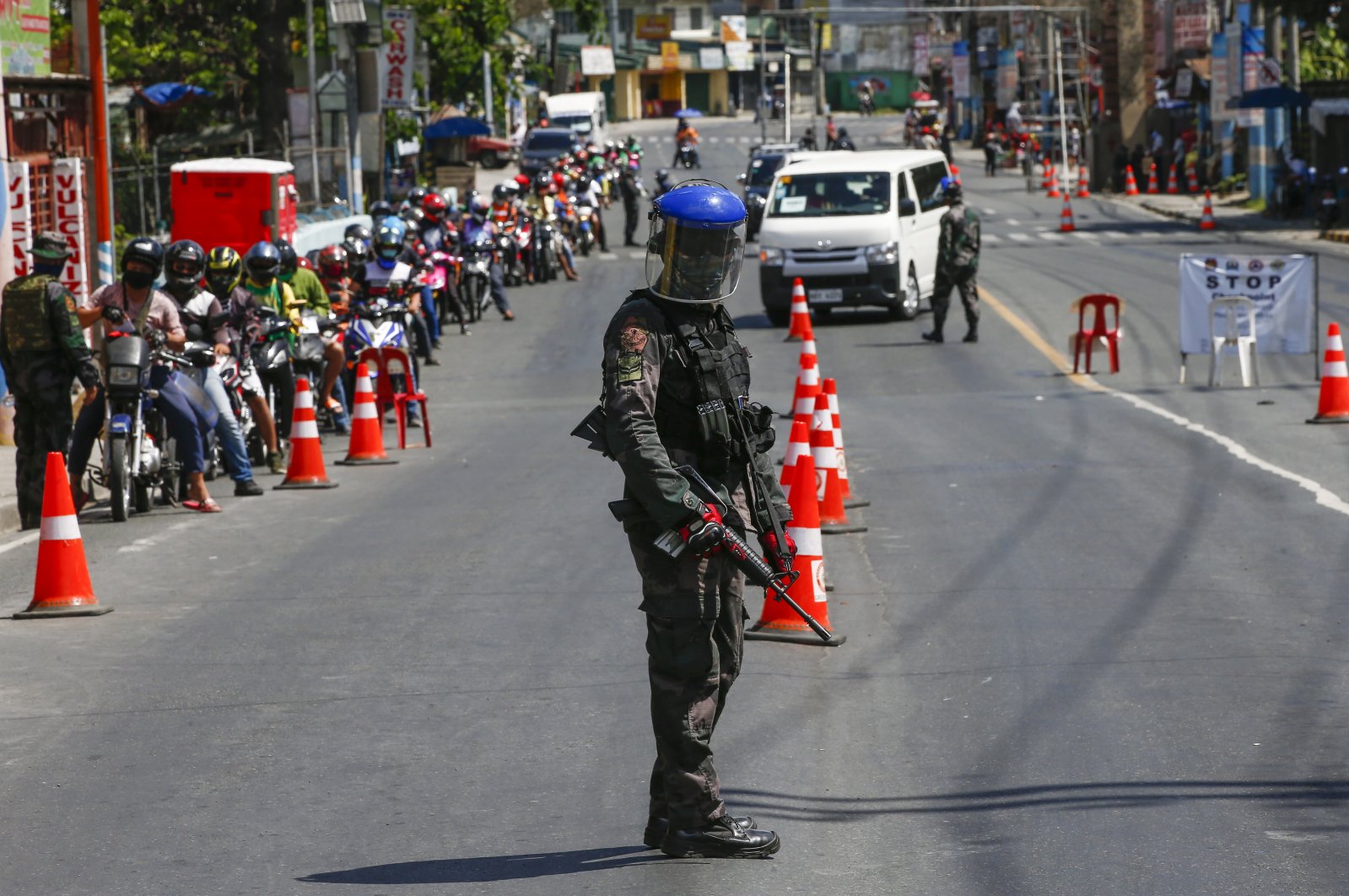 A police officer guards a checkpoint at the border between Rizal province and Marikina City, Metro Manila, Philippines, Thursday, April 2, 2020. (EPA Photo)