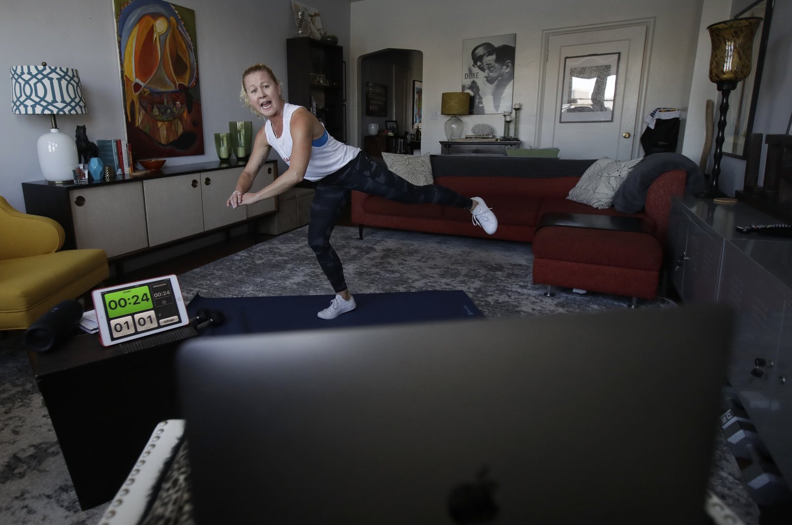 A woman shows how to perform a workout from her home in Oakland, California, U.S.,Thursday, March 26, 2020. (AP Photo)