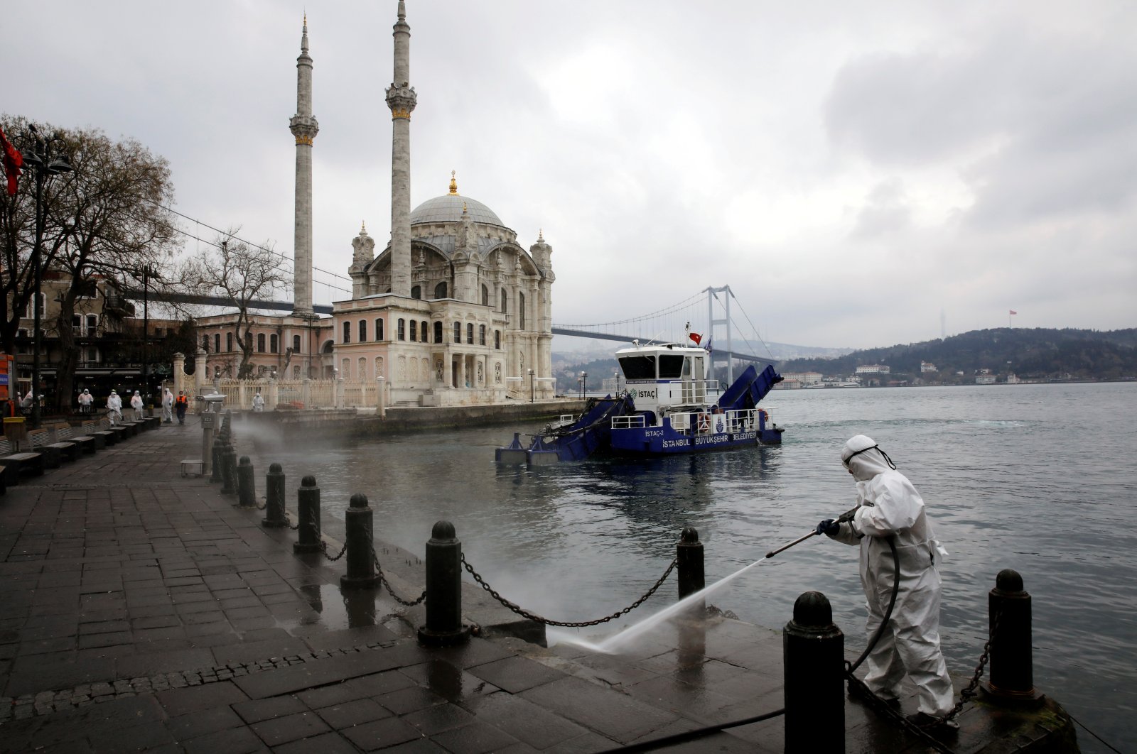 A worker sprays disinfectant outside Ortakoy Mosque, to prevent the spread of the new coronavirus disease (COVID-19), in Istanbul, Turkey, March 23, 2020. (Reuters Photo)