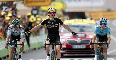 Simon Yates surrounded by Pello Bilbao Lopez De Armentia (R) and Gregor Muhlberger, as he crosses the finish line to win the twelfth stage of the Tour de France cycling race in Bagneres-de-Bigorre, France, July 18, 2019. (AP Photo)
