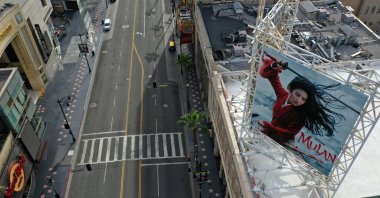 A poster of the "Mulan" movie, which was going to be released on March 27, towers over an empty Hollywood Boulevard, in Hollywood, Los Angeles, California, U.S., Tuesday, March 31, 2020. (Reuters Photo) 