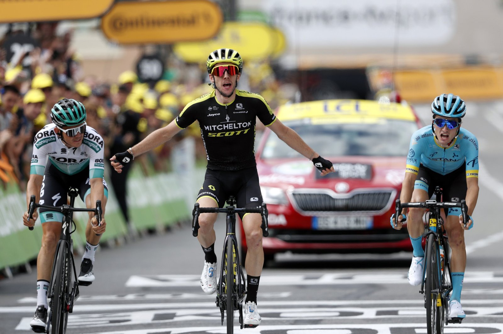 Simon Yates surrounded by Pello Bilbao Lopez De Armentia (R) and Gregor Muhlberger, as he crosses the finish line to win the twelfth stage of the Tour de France cycling race in Bagneres-de-Bigorre, France, July 18, 2019. (AP Photo)