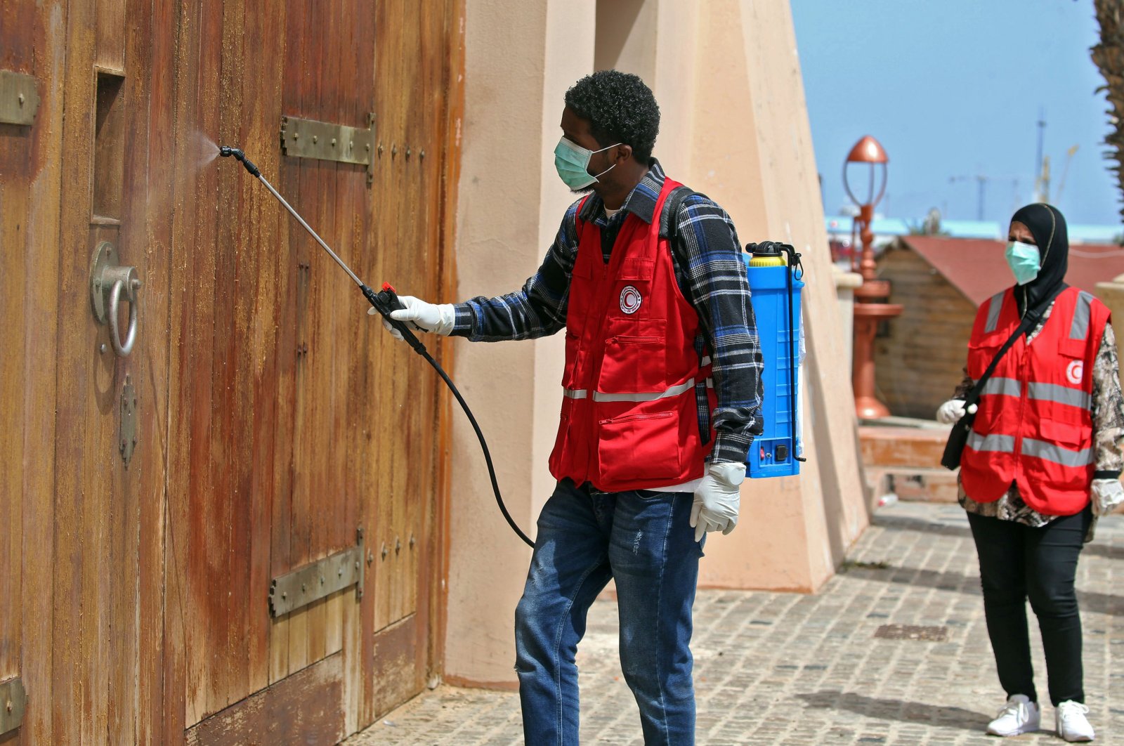 Members of the Libyan Red Crescent disinfect a street in the center of the capital Tripoli as a measure to stem the spread of the coronavirus, Wednesday, April 1, 2020. (AFP Photo)