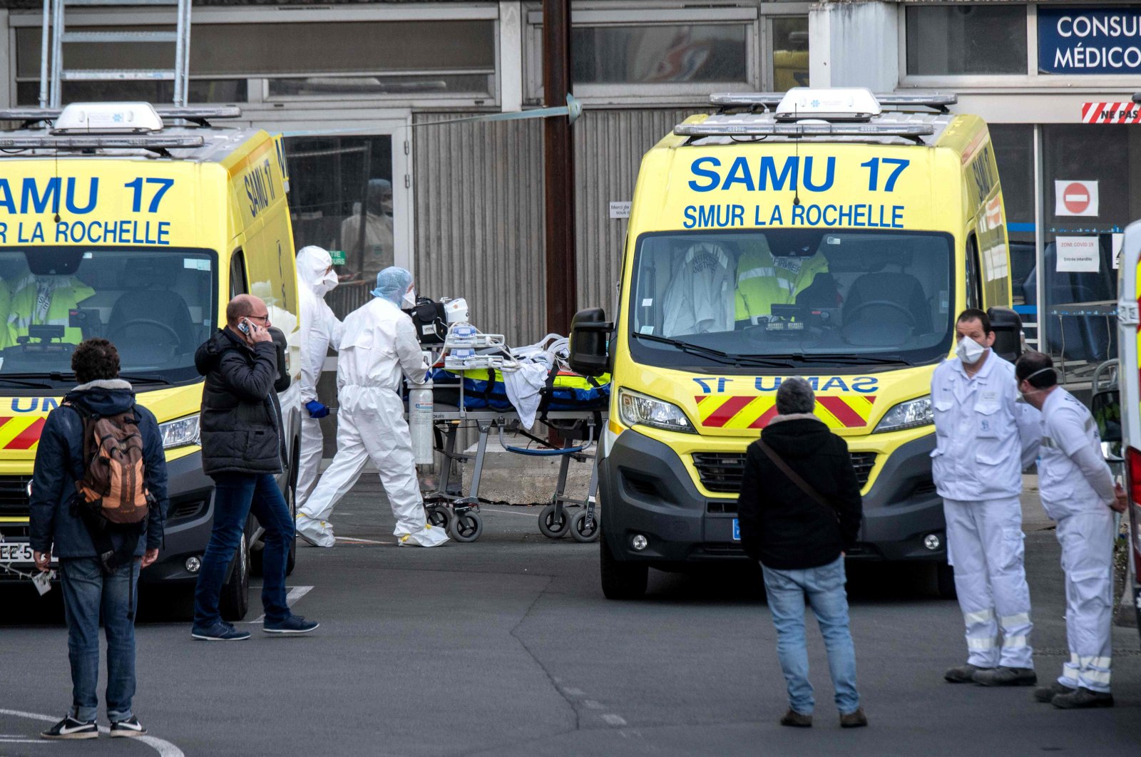 Emergency workers escort infected patients to the Saint-Louis hospital in La Rochelle, France, Friday, April 3, 2020. (AFP Photo)