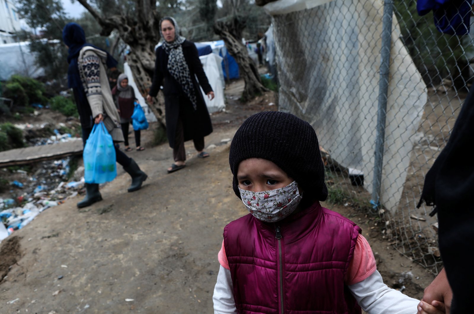 A girl wears a protective face mask at a makeshift camp for refugees and migrants in Lesbos, Greece, Thursday, April 2, 2020. (Reuters Photo)