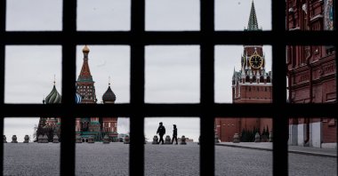 Police officers wearing face masks patrol the deserted Red Square, with St. Basil's Cathedral (L) and the Kremlin's Spasskaya Tower (R) in the background, Moscow, Monday, March 30, 2020. (AFP Photo)