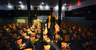 A man sorts donations for families in need during the COVID-19 pandemic in the holy city of Najaf, Iraq on March 25, 2020 (AFP Photo)
