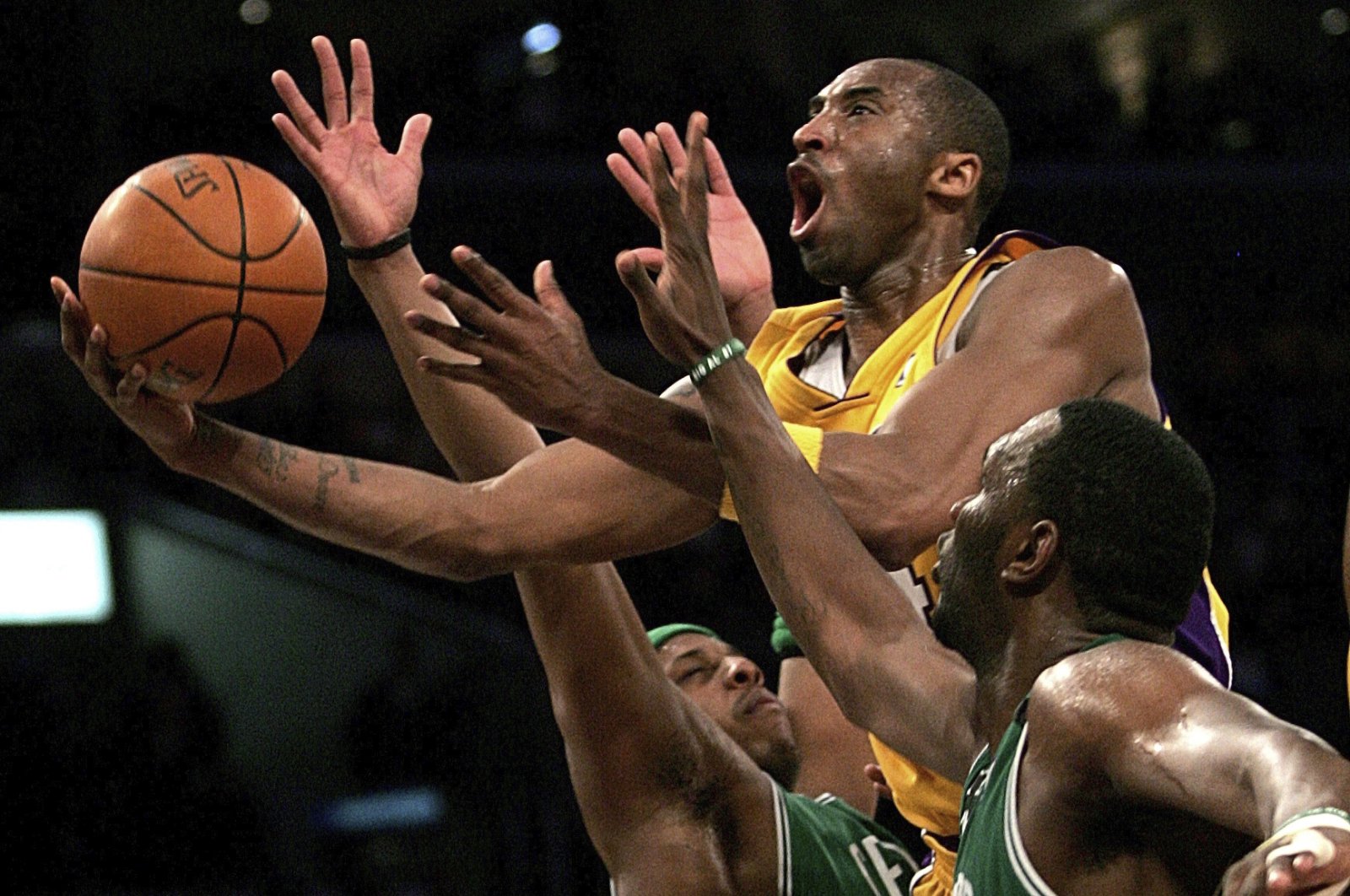 In this Feb. 23, 2007, file photo, Los Angeles Lakers' Kobe Bryant goes up for a shot between Boston Celtics' Paul Pierce and Al Jefferson during the first half of an NBA basketball game in Los Angeles.