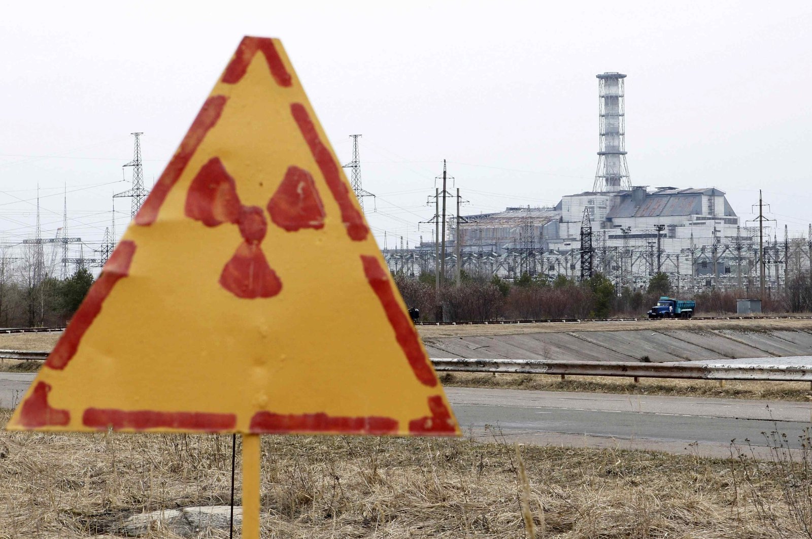 A radiation sign is seen, with a sarcophagus covering the damaged fourth reactor at the Chernobyl nuclear power plant in the background, April 4, 2011. (Reuters Photo)
