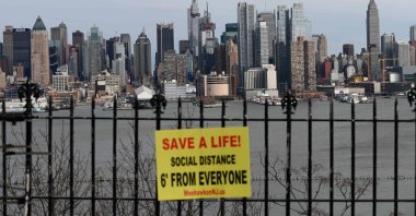 A sign hangs in a park overlooking the Manhattan skyline, as seen from Weehawken, New Jersey, Thursday, April 2, 2020. (AFP Photo)