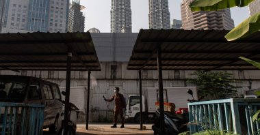 A man sprays disinfectant near a residential area during the Movement Control Order as a preventive measure against the spread of COVID-19, Kuala Lumpur, Malaysia, Tuesday, March 31, 2020. (AFP Photo)