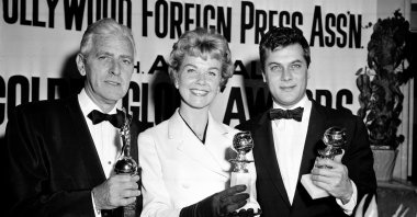 In this Feb. 26, 1958 file photo, actress Doris Day, center, Tony Curtis, right, and Buddy Adler pose with their awards presented to them by the Hollywood Foreign Press Association at its annual awards dinner in the Cocoanut Grove in Los Angeles. (AP Photo)