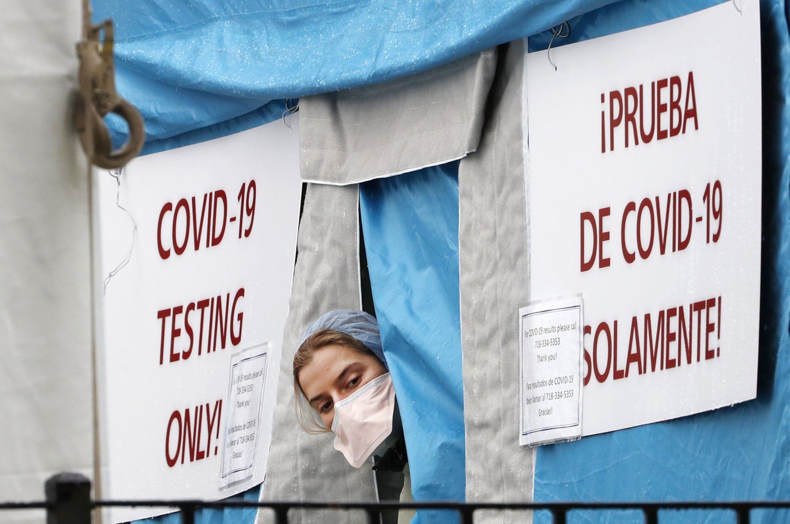 A medical worker sticks her head outside a COVID-19 testing tent set up outside Elmhurst Hospital Center in New York, Saturday, March 28, 2020. (AP Photo)