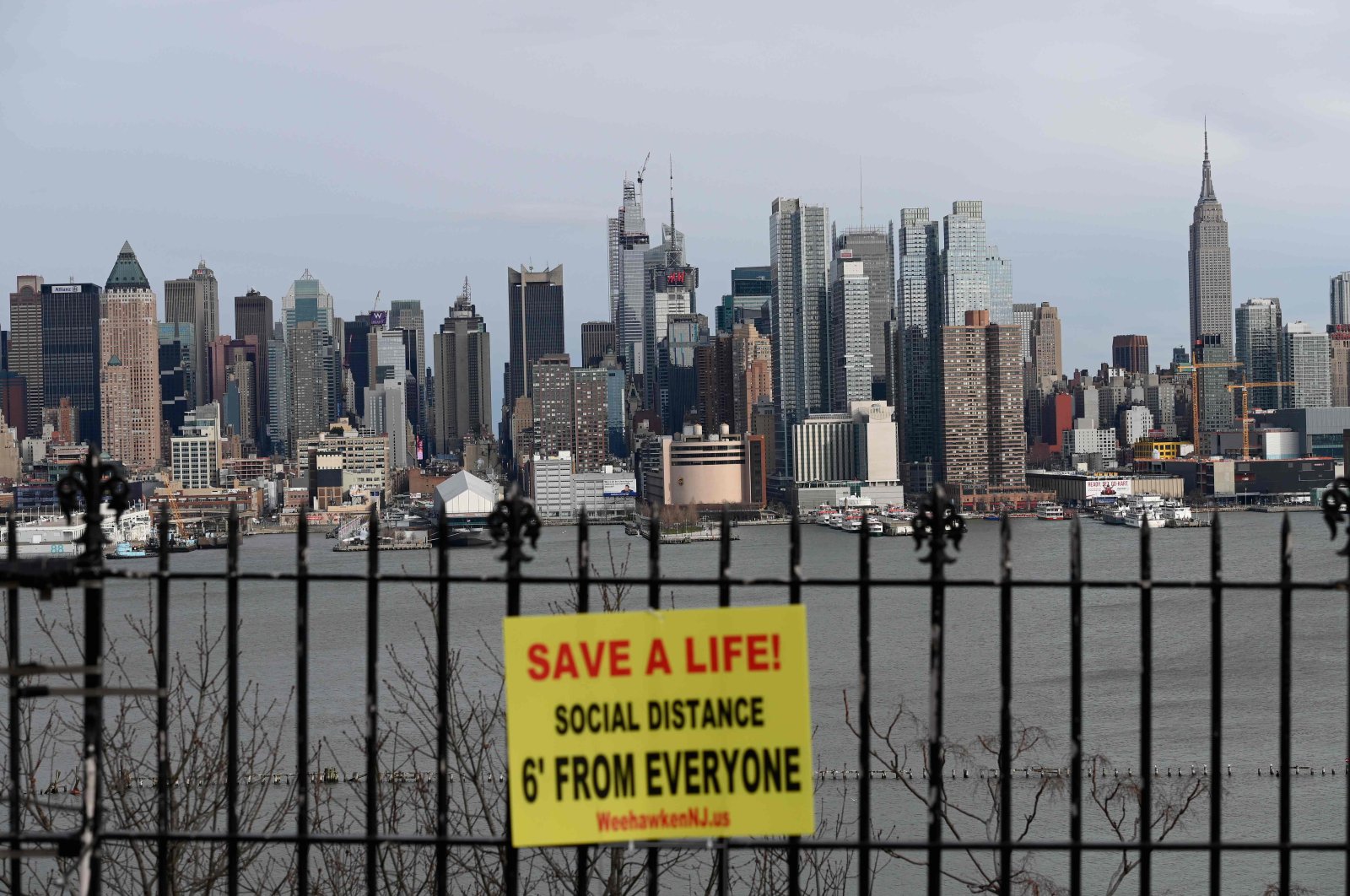 A sign hangs in a park overlooking the Manhattan skyline, as seen from Weehawken, New Jersey, Thursday, April 2, 2020. (AFP Photo)