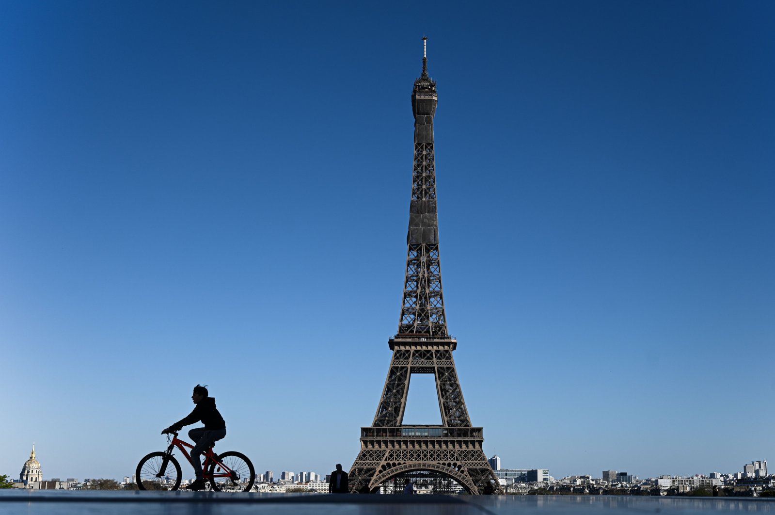 A boy rides his bicycle past the Eiffel Tower in Paris on Sunday, April 5, 2020, the 20th day of a lockdown in France aimed at curbing the spread of COVID-19. (AFP Photo)