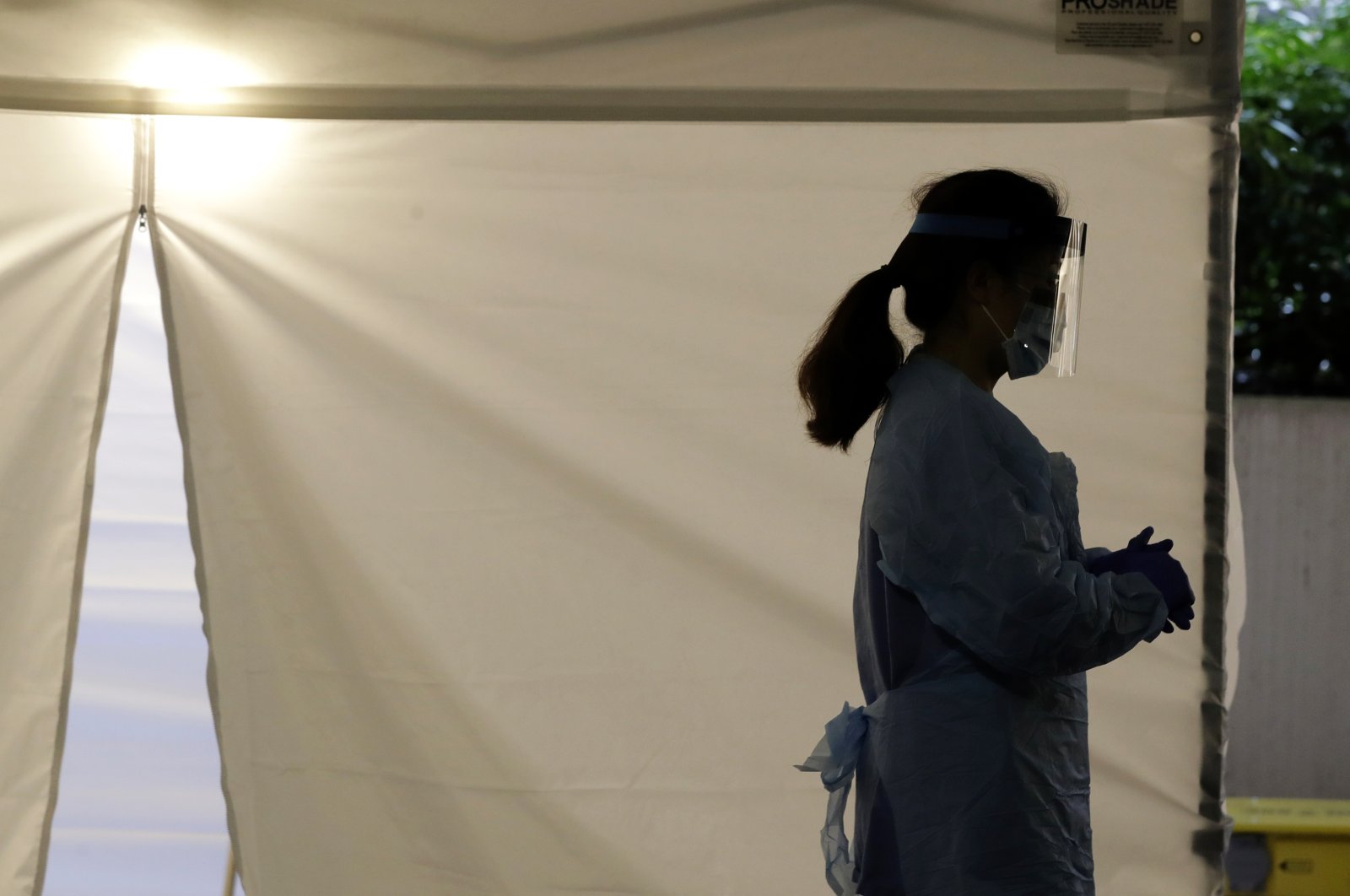 In this March 13, 2020, file photo, a nurse at a drive-up coronavirus testing station set up by the University of Washington Medical Center wears a face shield and other protective gear as she waits by a tent in Seattle. (AP Photo)